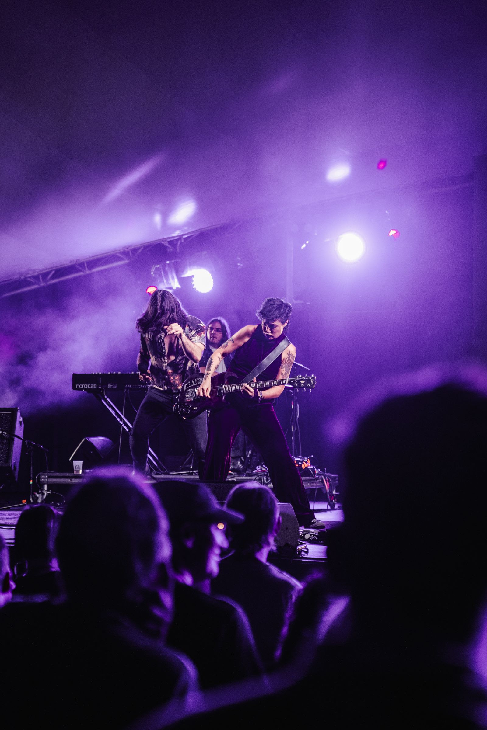 a group of people playing guitar on a stage in front of a crowd
