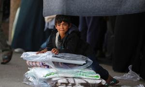 Un niño sentado junto a las mantas repartidas en un refugio de la UNRWA en Deir al-Balah, Gaza.