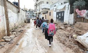 Unos niños caminan por las calles parcialmente destruidas de Yenín, en Cisjordania.