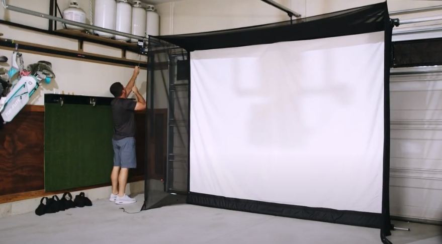 A person standing in front of a large screen
Description automatically generated