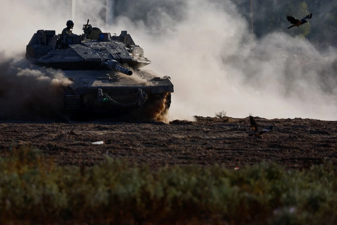 A tank on open ground with smoke rising behind it