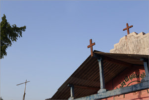 Three crosses are seen against a clear blue sky.