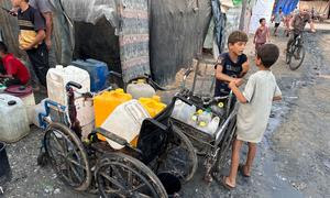 Niños recolectando agua en Gaza.