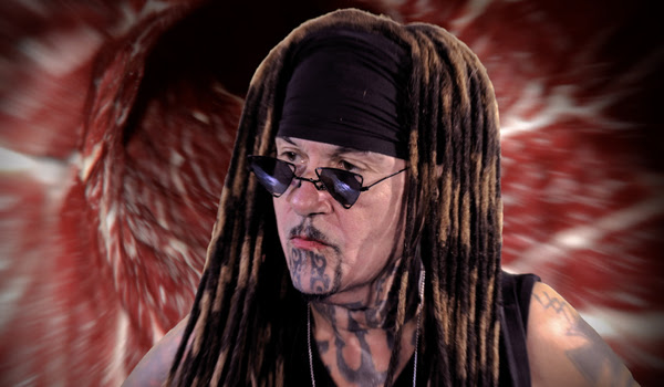 A person with dreadlocks and a tattoo on his neckDescription automatically generated