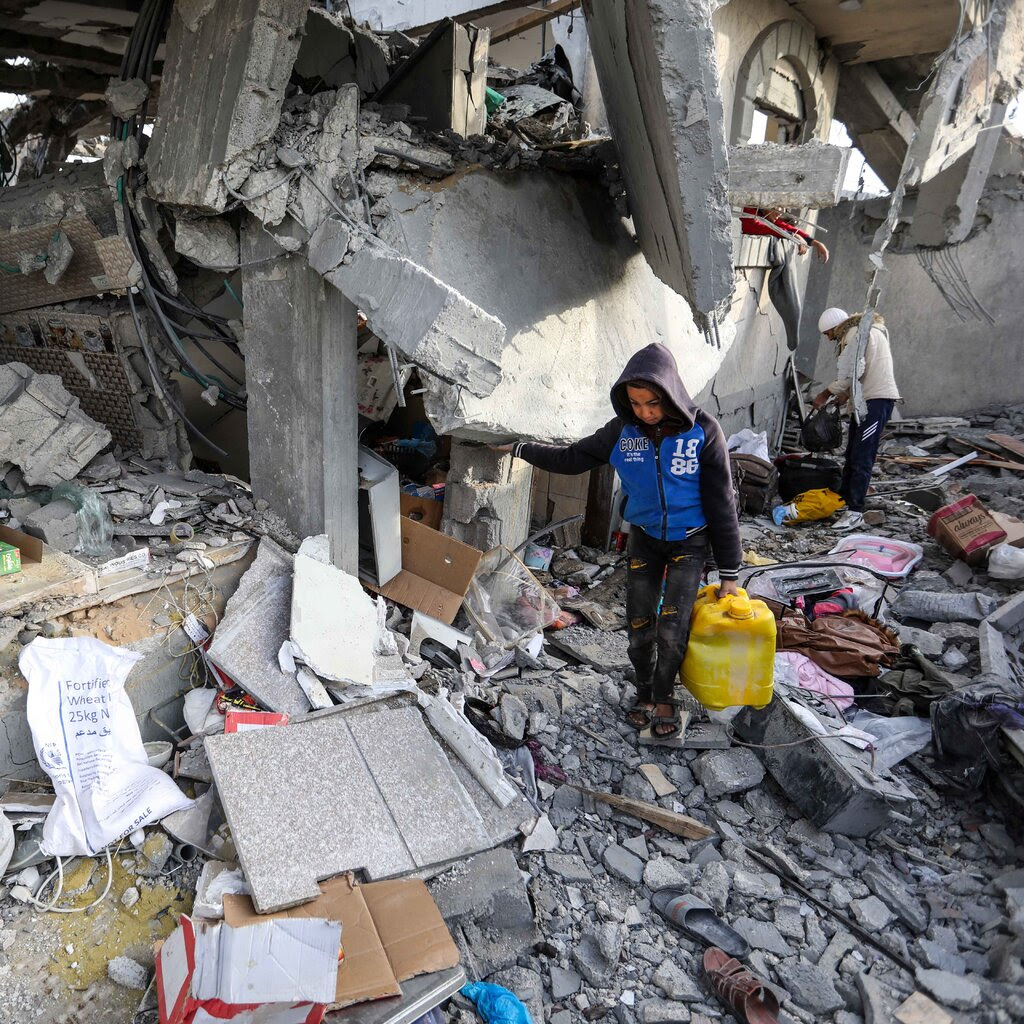 Two people pick through the wreckage of a building in Rafah, Gaza.