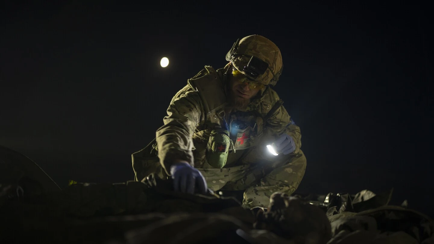 Oleksii Yukov examines the body of a Russian soldier he collected on the frontline in the Sloviansk region, Ukraine.