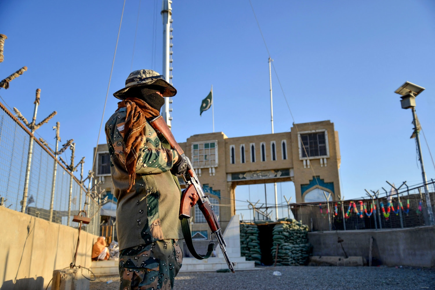 Afghan security stands guard at a fenced corridor of the Afghanistan-Pakistan border in Spin Boldak, Afghanistan.