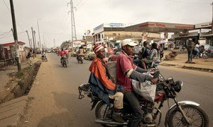 Una mujer carga sus sacos de productos en un mototaxi para regresar a su casa en Camerún.