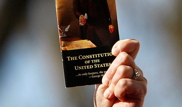 In this file photo, a rally participant holds up a pocket-sized copy of the U.S. Constitution during an anti-health-care-reform rally by The American Grassroots Coalition and The Tea Party Express on Capitol Hill in Washington, Tuesday, March 16, 2010. (AP Photo/Gerald Herbert)