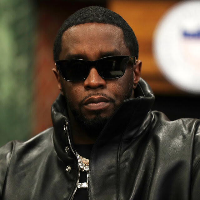 Sean Combs, in a black leather jacket and dark sunglasses.