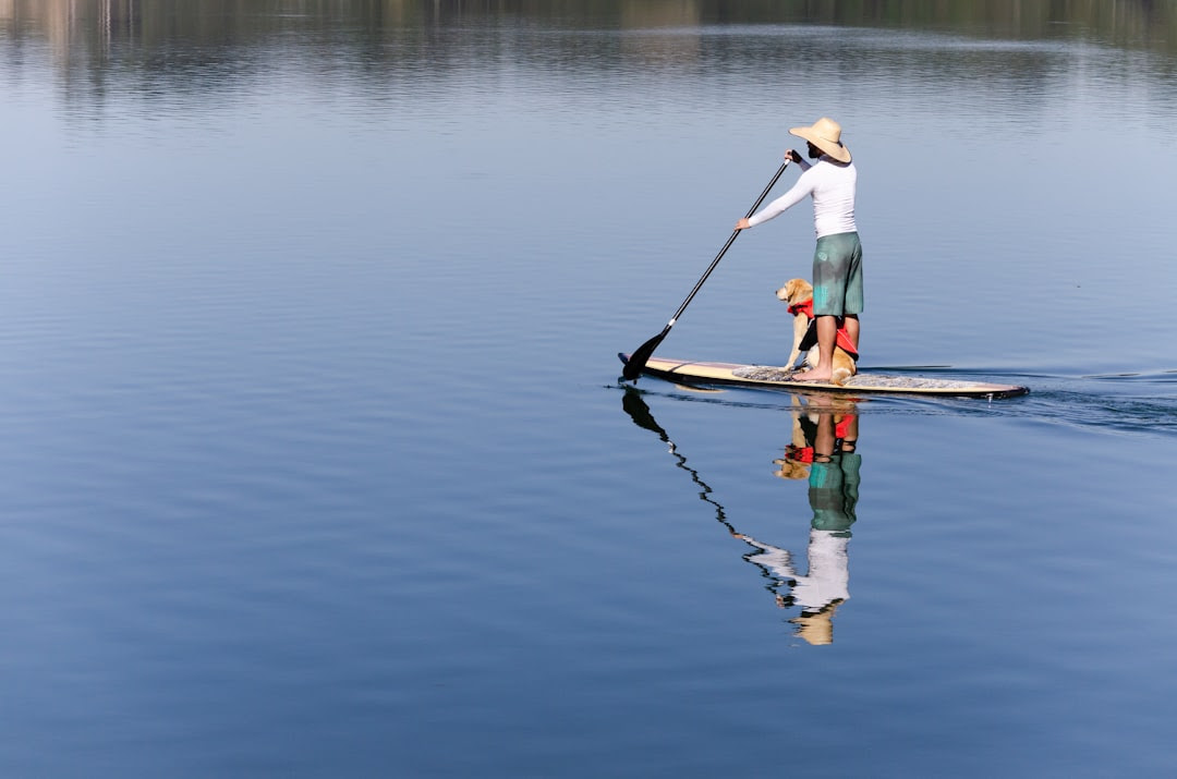 man standing on boat holding boat paddle