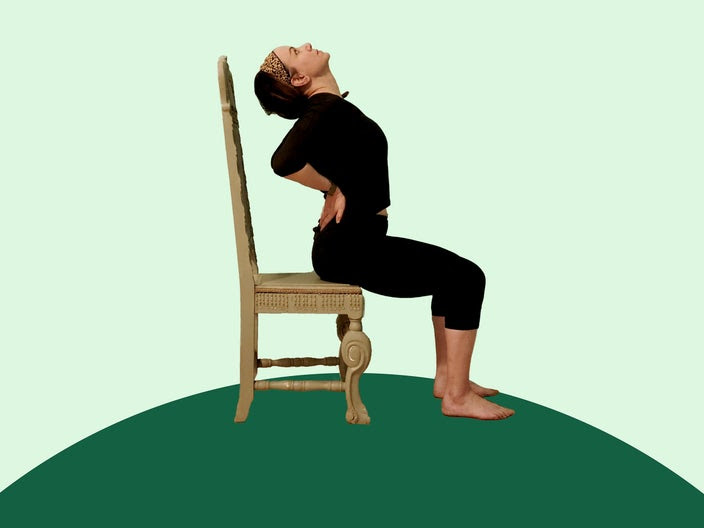 Woman doing chair yoga camel pose on green background.