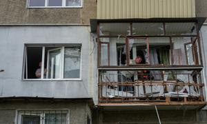 Varios hombres trabajan en un edificio de apartamentos dañado en un ataque en Poltava, ciudad del centro de Ucrania.