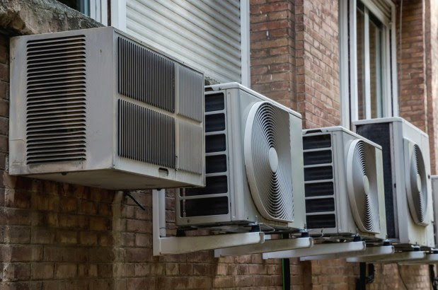 Air conditioner systems in the wall of a building. Air conditioning is based in removing heat from a confined space to achieve a more comfortable interior environment generic air conditioning units