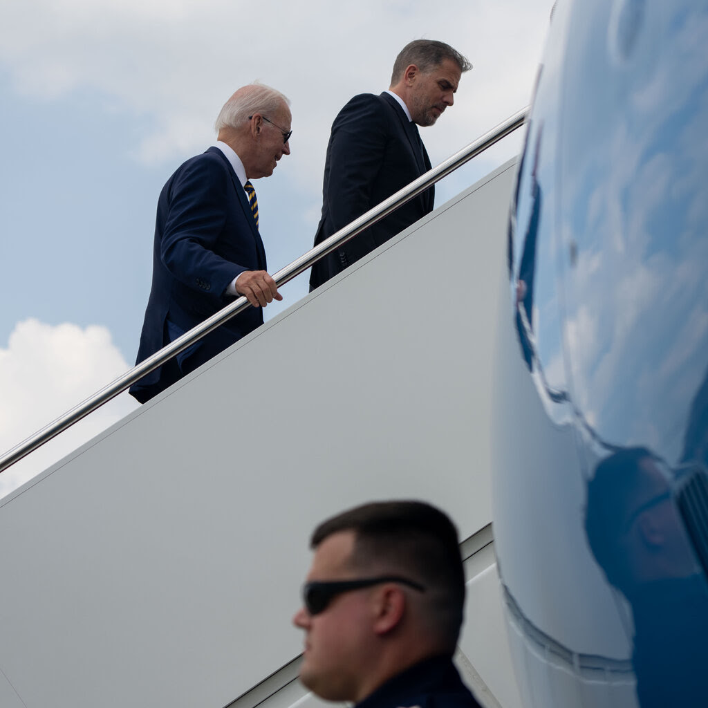 President Biden and Hunter Biden climb the stairs into a jet. 