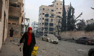 Una mujer camina junto a su casa destruida en la zona del Estadio Palestino, en el centro de la ciudad de Gaza. (archivo)