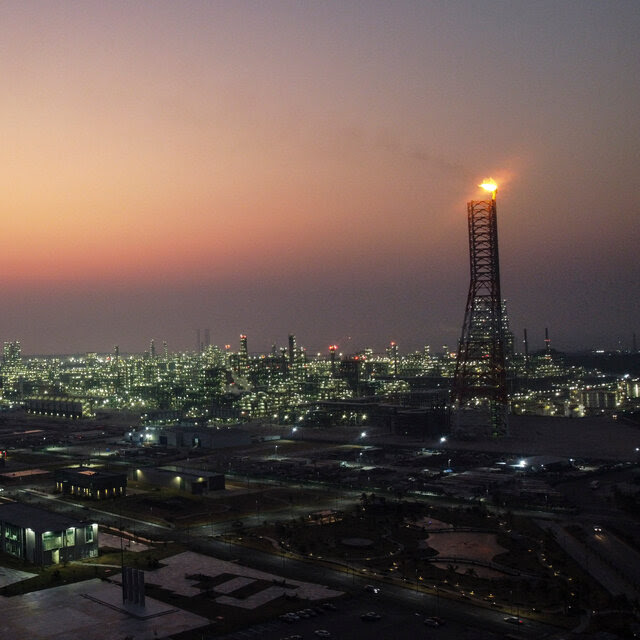 A twilight view of an oil refinery. Its lights make it look almost like a city.