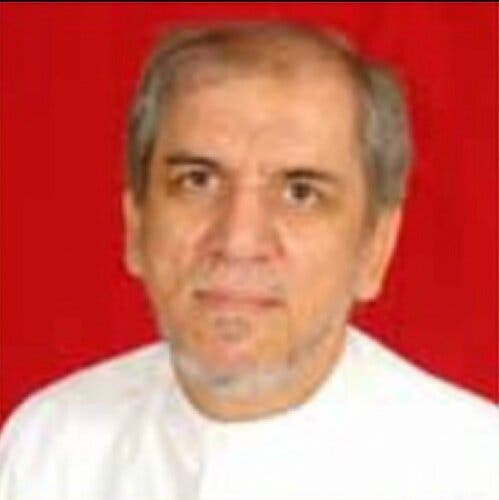 Hisham Qafisheh in a white shirt against a red background.