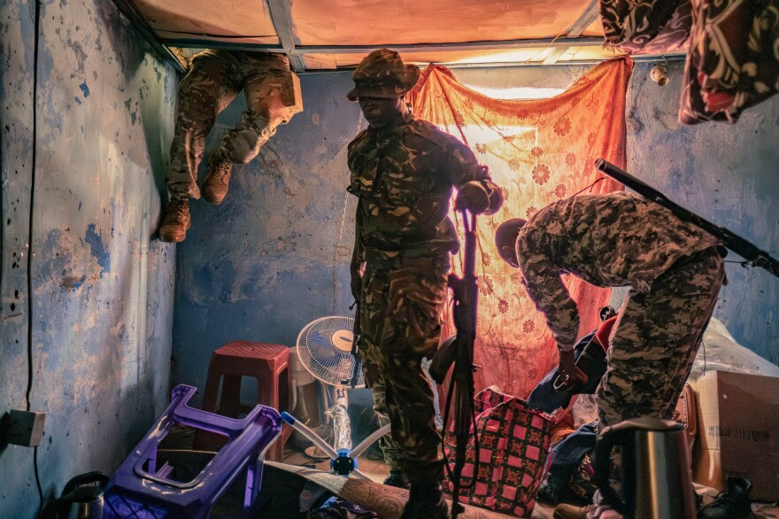 A soldier searches inside the roof cavity of the home of a suspected kush dealer in Waterloo, Sierra Leone. The officers say they discovered large quantities of kush in the house and made several arrests.