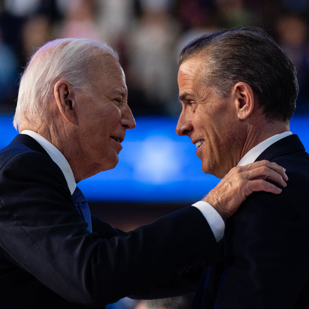 President Biden puts his hand on his son Hunter’s shoulder.