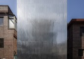 La fachada sin ventanas se compone por una serie de tablones de acero ligero ondulado.