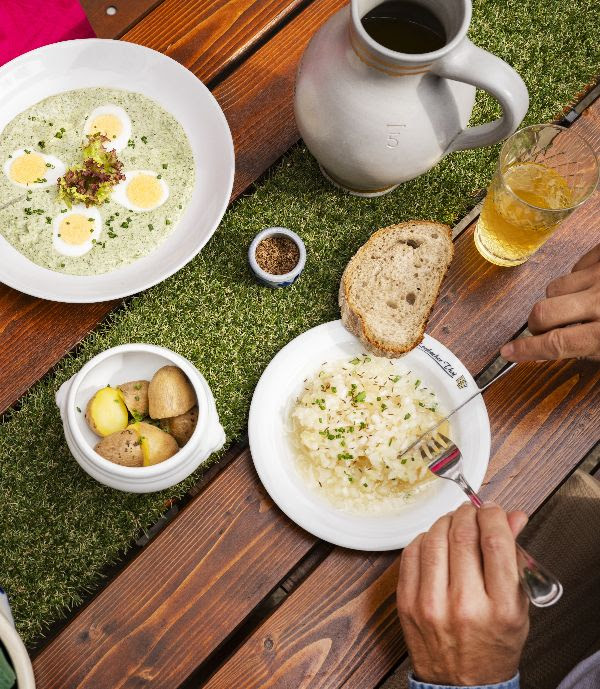 A table with traditional Frankfurt green sauce with eggs, potatoes and a glass of cider in a cozy cider tavern