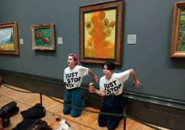 Activists of "Just Stop Oil" glue their hands to the wall after throwing soup at a van Gogh's painting "Sunflowers" at the National Gallery in London, Britain October 14, 2022. Just Stop Oil/Handout via Reuters