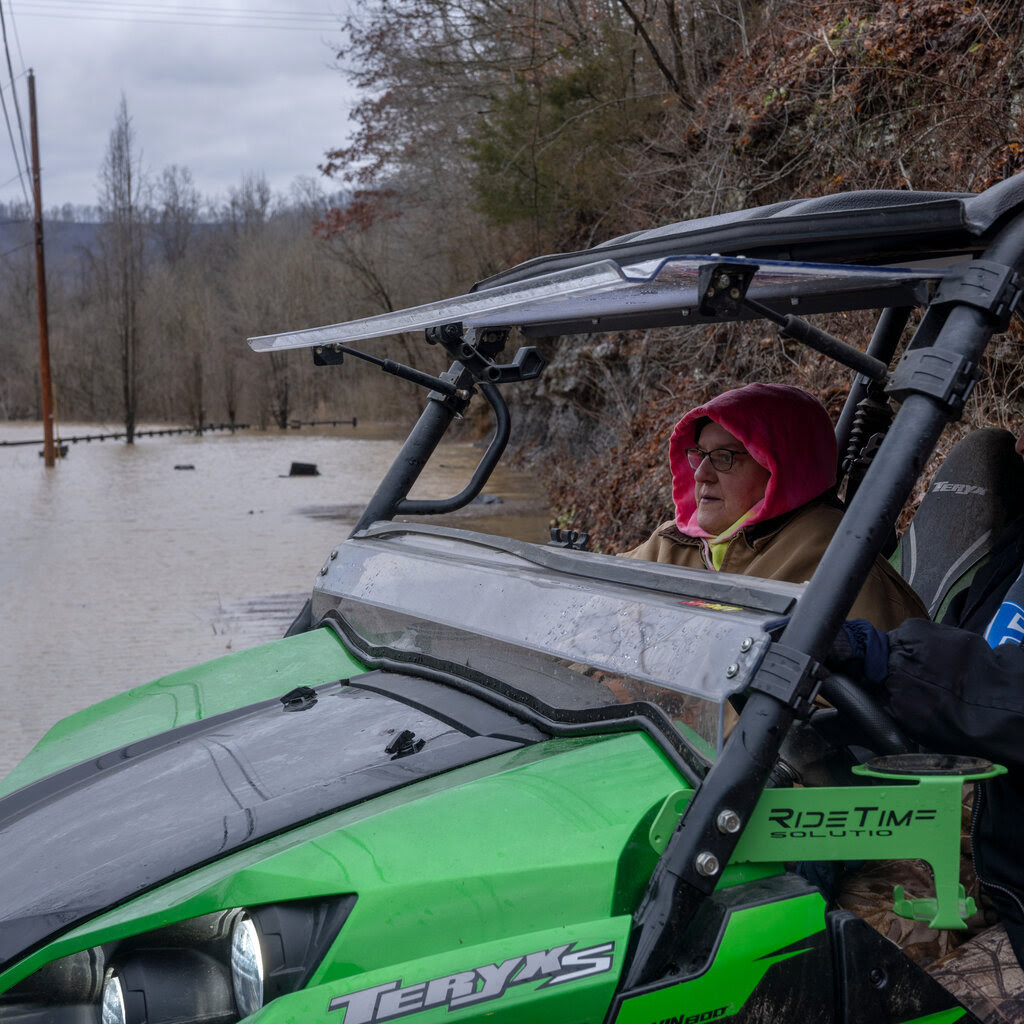 A woman above a flooded stream.