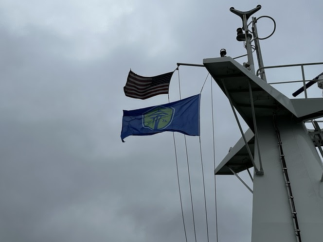 American and Seattle Sounders team flags flying atop a ferry