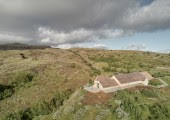 Una ventana panorámica enmarca el paisaje y ofrece una perspectiva única desde una terraza exterior.