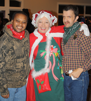 Two guests at the Holiday Hoedown pose with Mrs. Claus