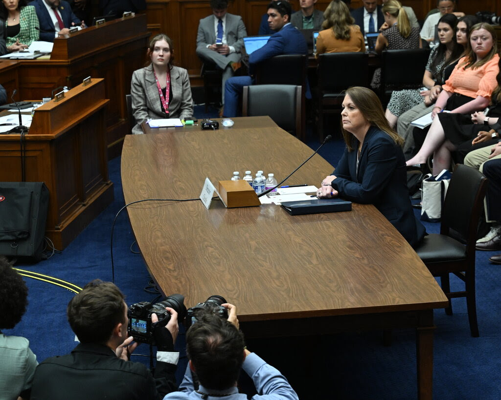 The director of the Secret Service sitting at a table in front of a microphone during a hearing in Congress.