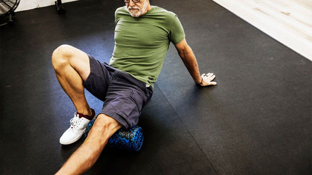 Older male doing PT stretches on the floor