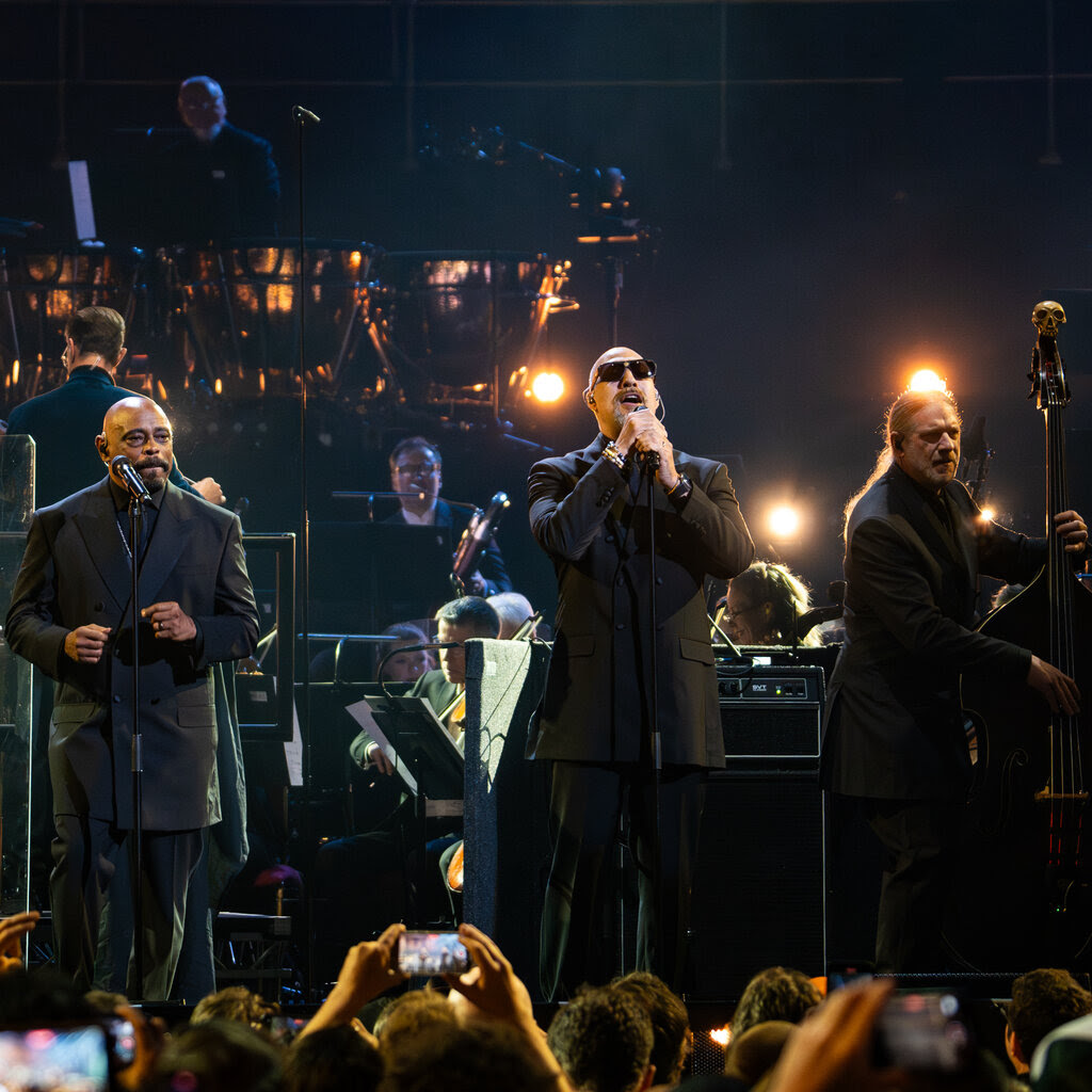 Sen Dog and B Real of Cypress Hill, dressed in black, perform with the London Symphony Orchestra on a stage in front of an audience.