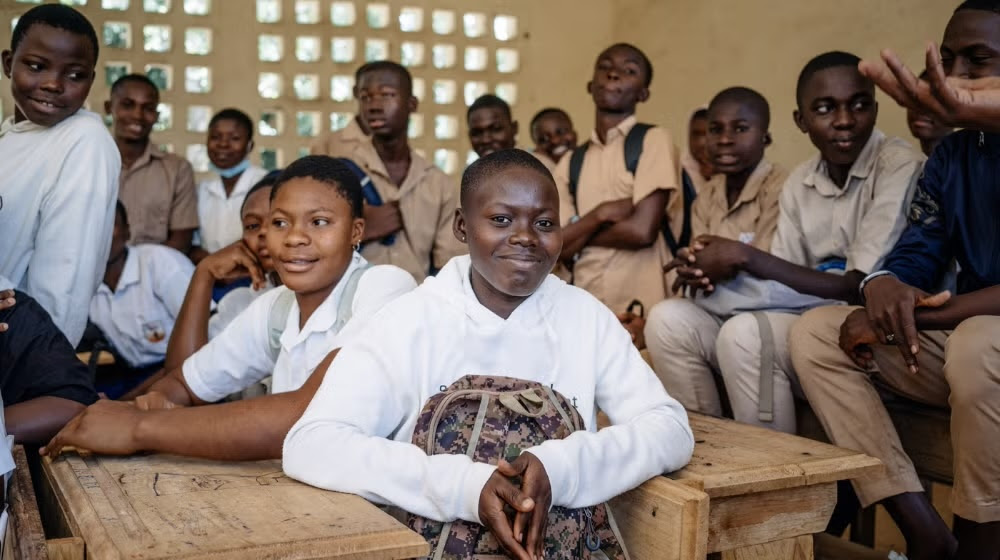 Young girls sitting at desks and smiling