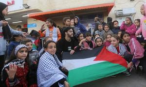 Unos niños de Gaza muestran la bandera palestina tras el alto el fuego.