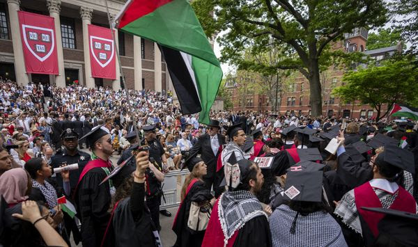 Graduating students hold Palestinian flags and chant as they walk out in protest over the 13 students who have been barred from graduating due to protest activities, during commencement in Harvard Yard, at Harvard University, in Cambridge, Mass., Thursday, May 23, 2024. (AP Photo/Ben Curtis, File)