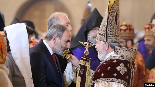 Armenia -- Prime Minister Nikol Pashinian kisses a cross held by Catholicos Garegin II during an Easter Mass at Yerevan's St. Gregory the Illuminator Cathedral, April 21, 2019.