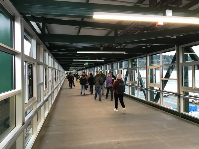 People walking through new overhead pedestrian walkway at Bainbridge terminal