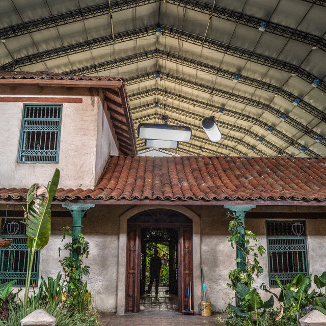 A house with a garden and is shown under an enormous hangar. 