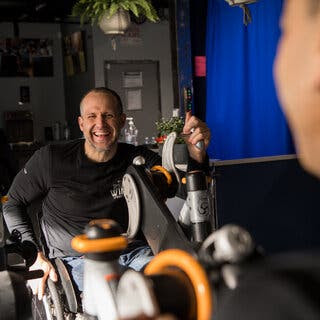 Yannick Benjamin smiles as he works out at an adaptive gym.