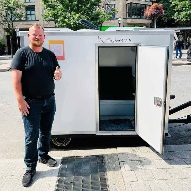 Ryan Donais standing outside of one of his Tiny Tiny Homes