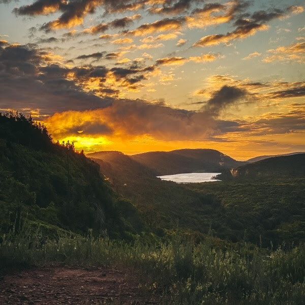 A stunning sunrise crests over mountain forests overlooking the Lake of the Clouds