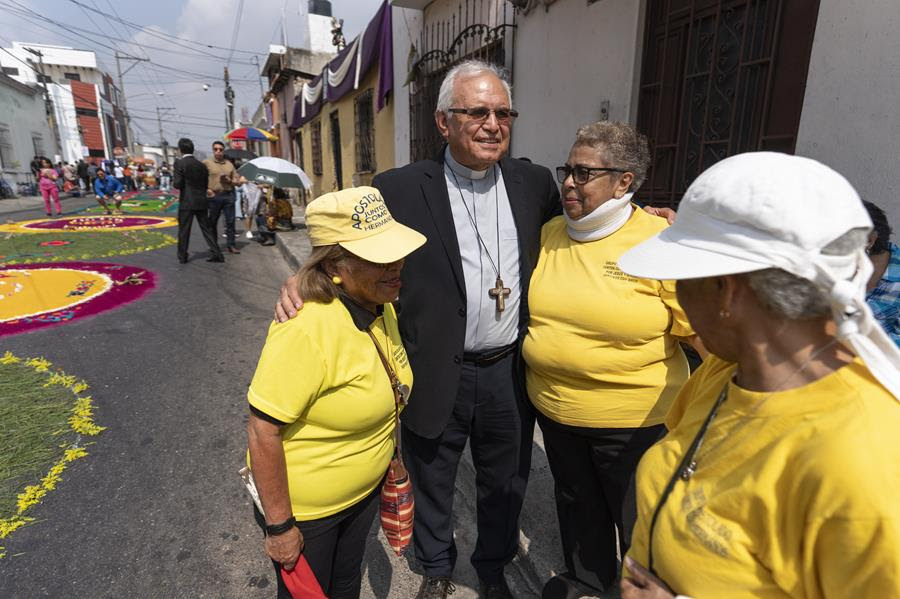 Cardinal Álvaro Ramazzini smiles and poses with women on the street.