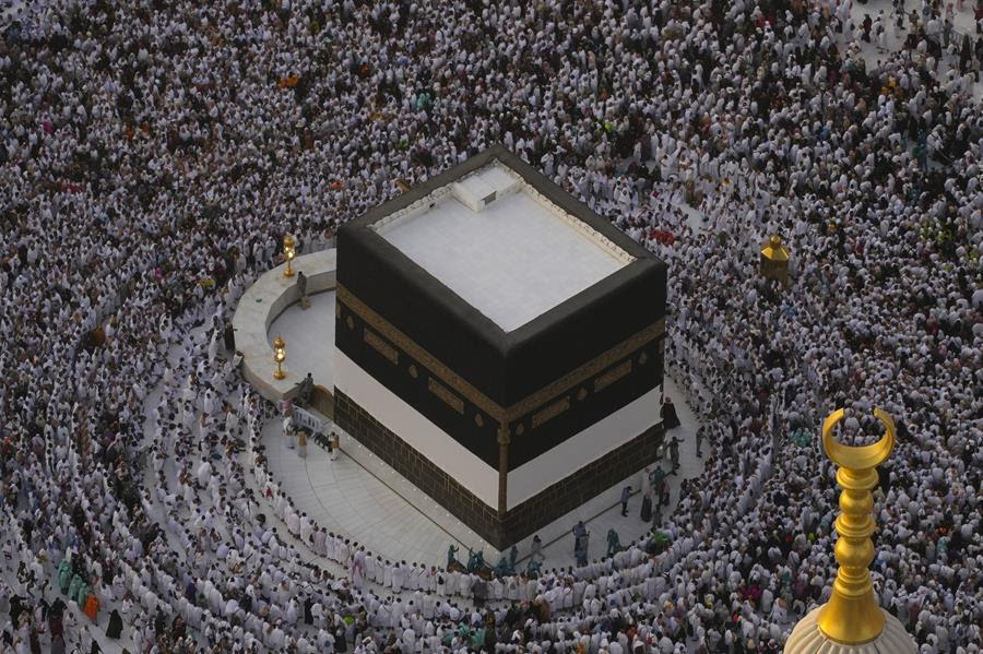An overhead view of the Kaaba in the holy city of Mecca. Muslim pilgrims are gathered around the Kaaba.