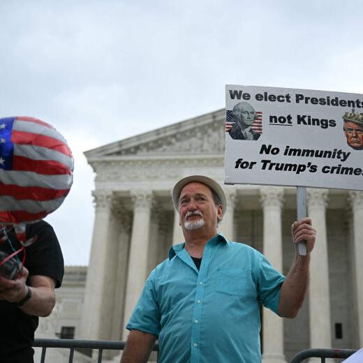 A man holds a placard in front of the US Supreme Court on July 1, 2024, in Washington, DC. The US Supreme Court is expected to rule Monday on the most highly anticipated decision of its term -- a ruling "for the ages" on whether Donald Trump, as a former president, is immune from prosecution. . (Photo by Drew ANGERER / AFP)
