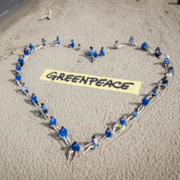 Actie waarbij actievoerders van Greenpeace een samen een groot hart vormen voor de oceanen.