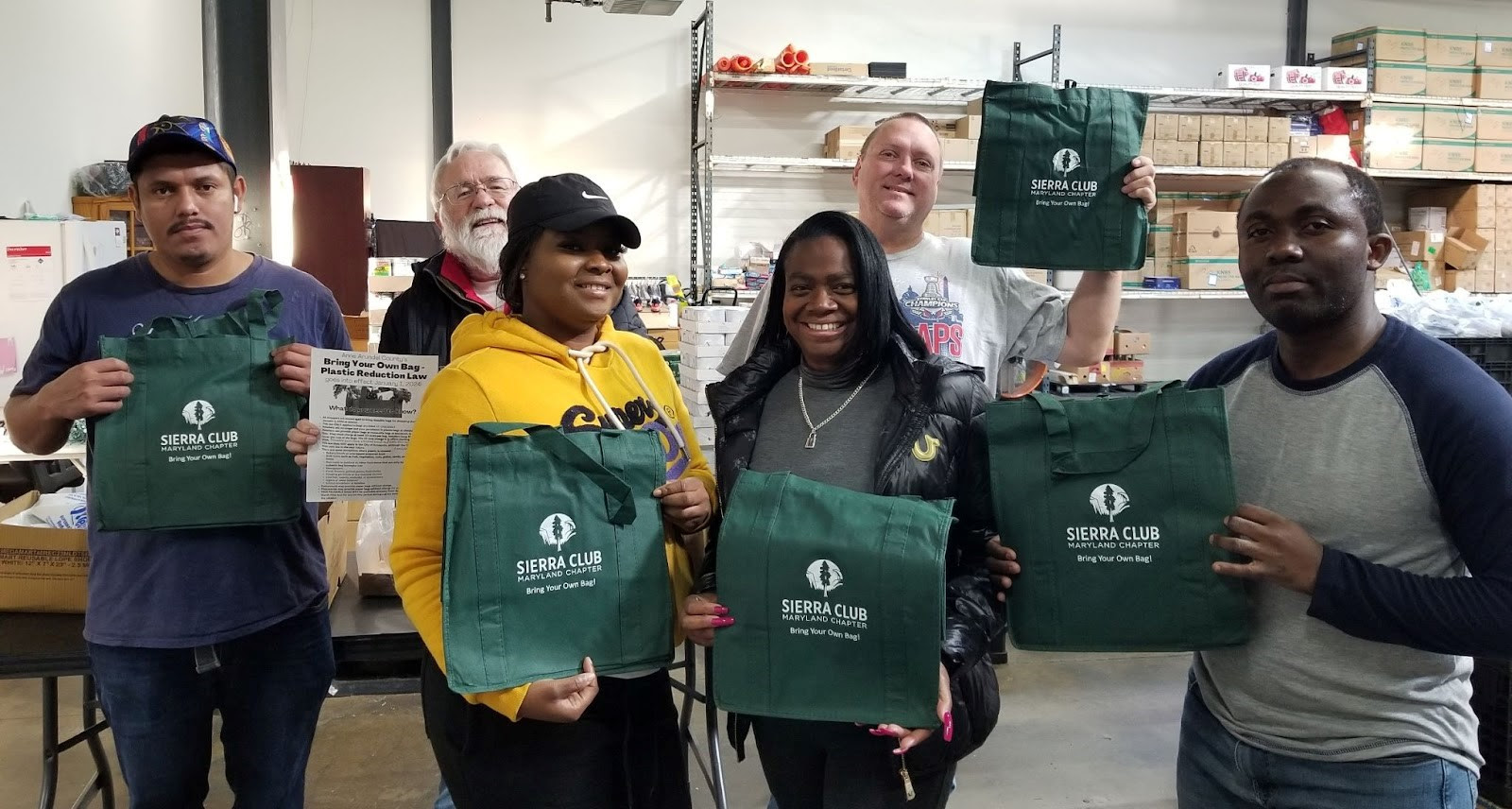 volunteers with reusable sierra club shopping bags