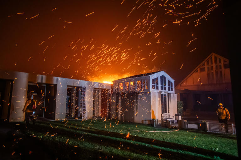 LOS ANGELES, CALIFORNIA – JANUARY 8: A Firefighter watches the flames from the Palisades Fire burning in front of the Pacific Palisades Presbyterian Church during a powerful windstorm on January 8, 2025 in the Pacific Palisades neighborhood of Los Angeles, California. The fast-moving wildfire is threatening homes in the coastal neighborhood amid intense Santa Ana Winds and dry conditions in Southern California. (Photo by Apu Gomes/Getty Images)