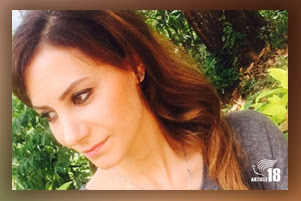 A smiling Laleh is outside, and the sun is shining on her face. Greenery is in the background.